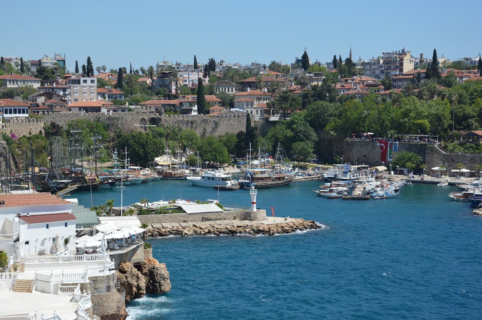 Beautiful view of Antalya's historic harbor with boats and a vibrant old town backdrop.