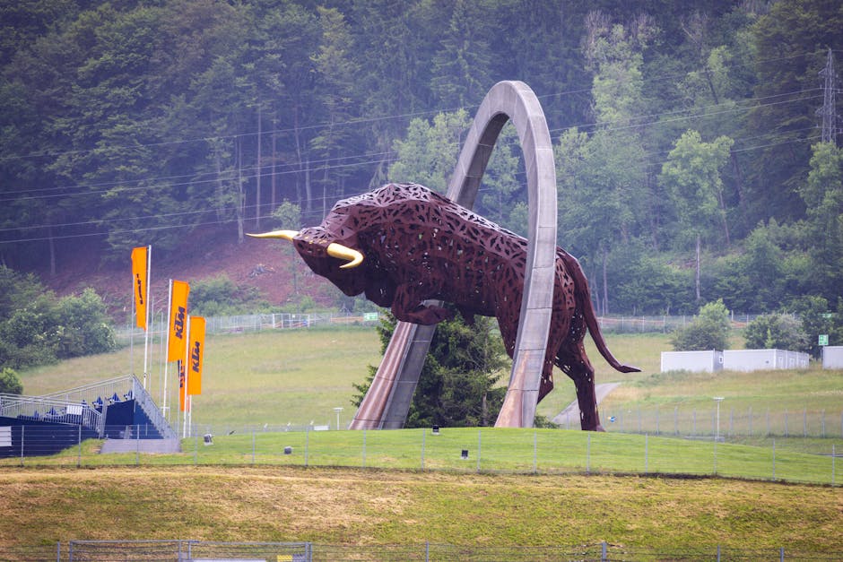Large bull sculpture at Red Bull Ring circuit with lush green backdrop.