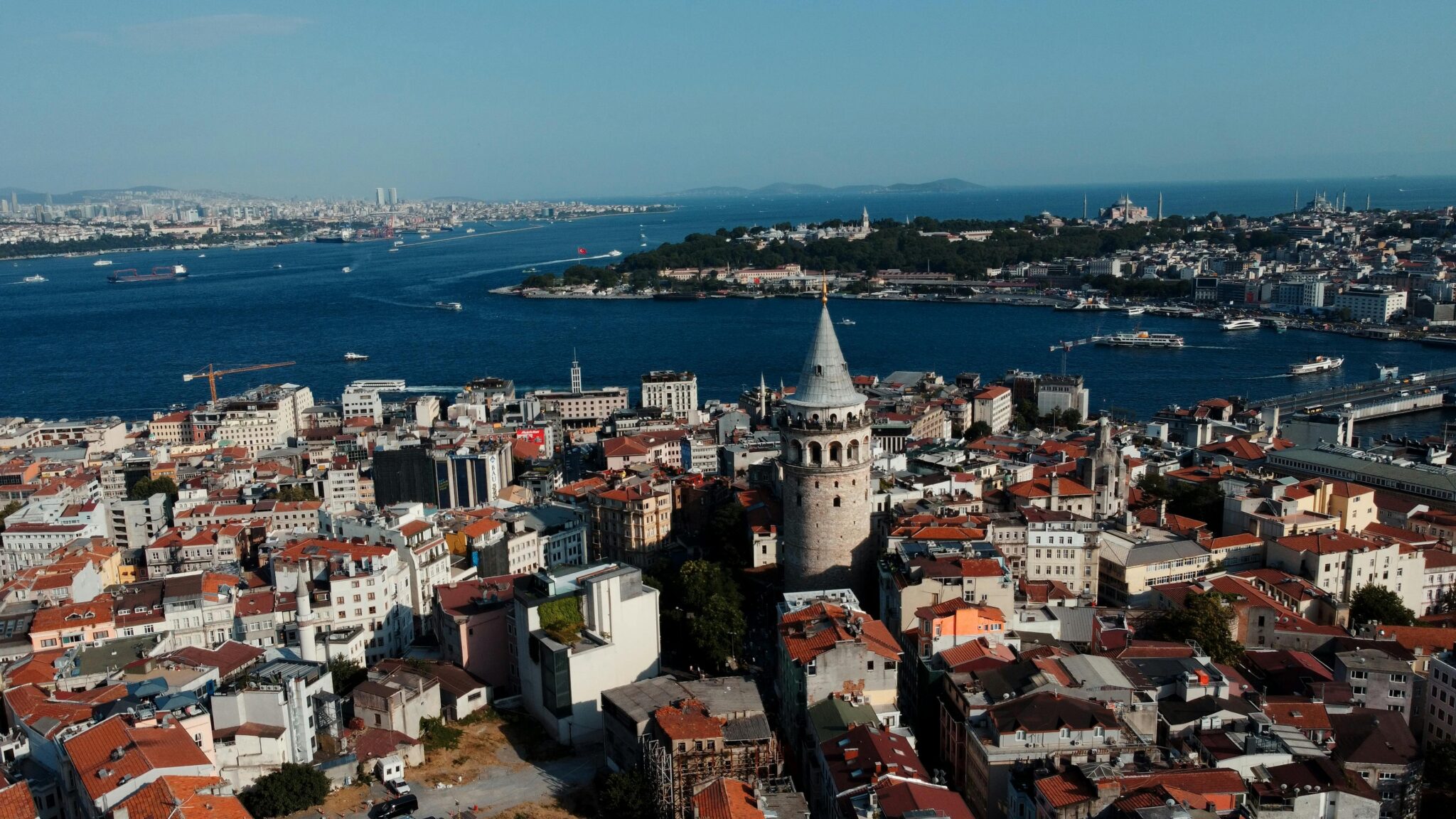 Aerial shot of Galata Tower and the cityscape of Istanbul, featuring the Bosphorus and historic architecture.