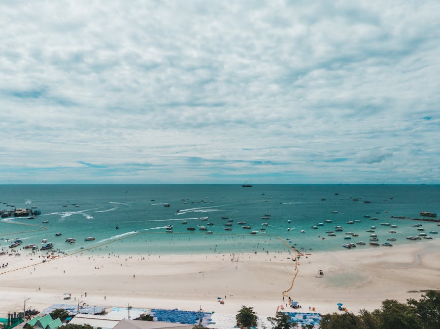 A stunning aerial view of Pattaya Beach in Chon Buri, Thailand, showcasing blue waters and boats.
